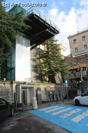 P03 [DEC-2022] San Marino, Piazzale Marino Calcigni unde este stația terminală a Shuttle Bus, se vede liftul în stânga sau se poate urca pe scări în dreapta la Piazzale Lo Stradone